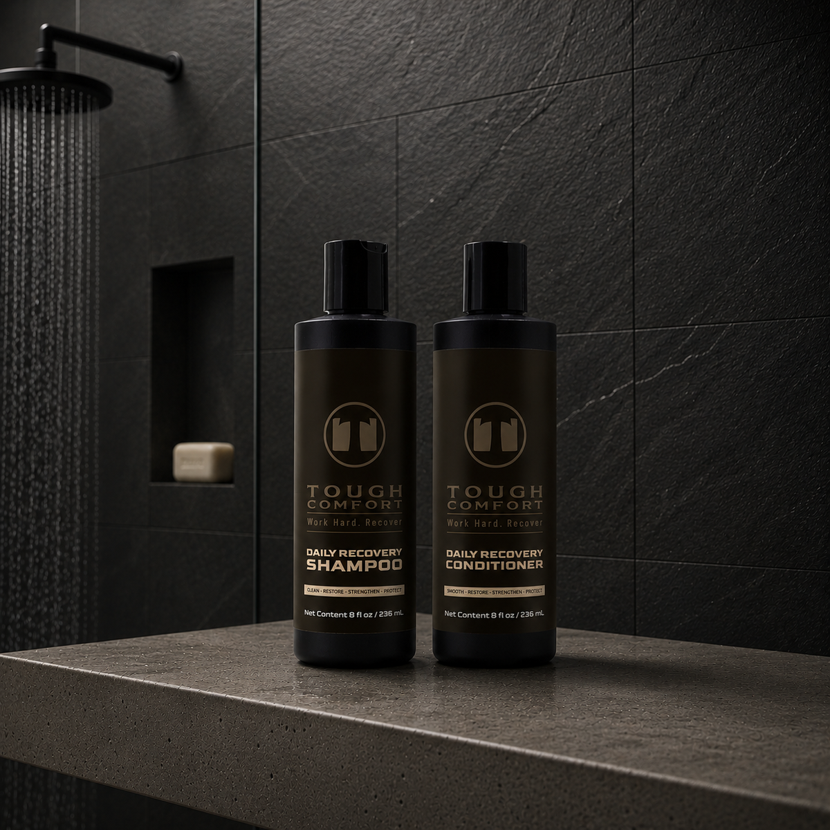 Tough Comfort Daily Recovery Shampoo and Conditioner on a stone shower ledge.